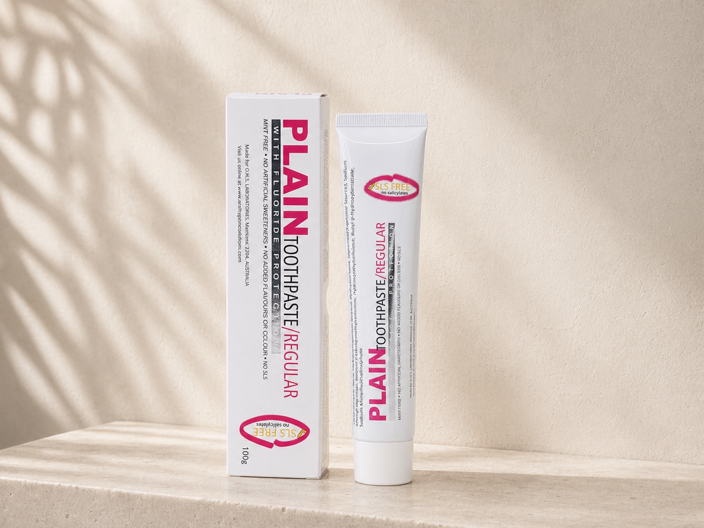 Plain Toothpaste Regular 100g carton and tube on a stone surface